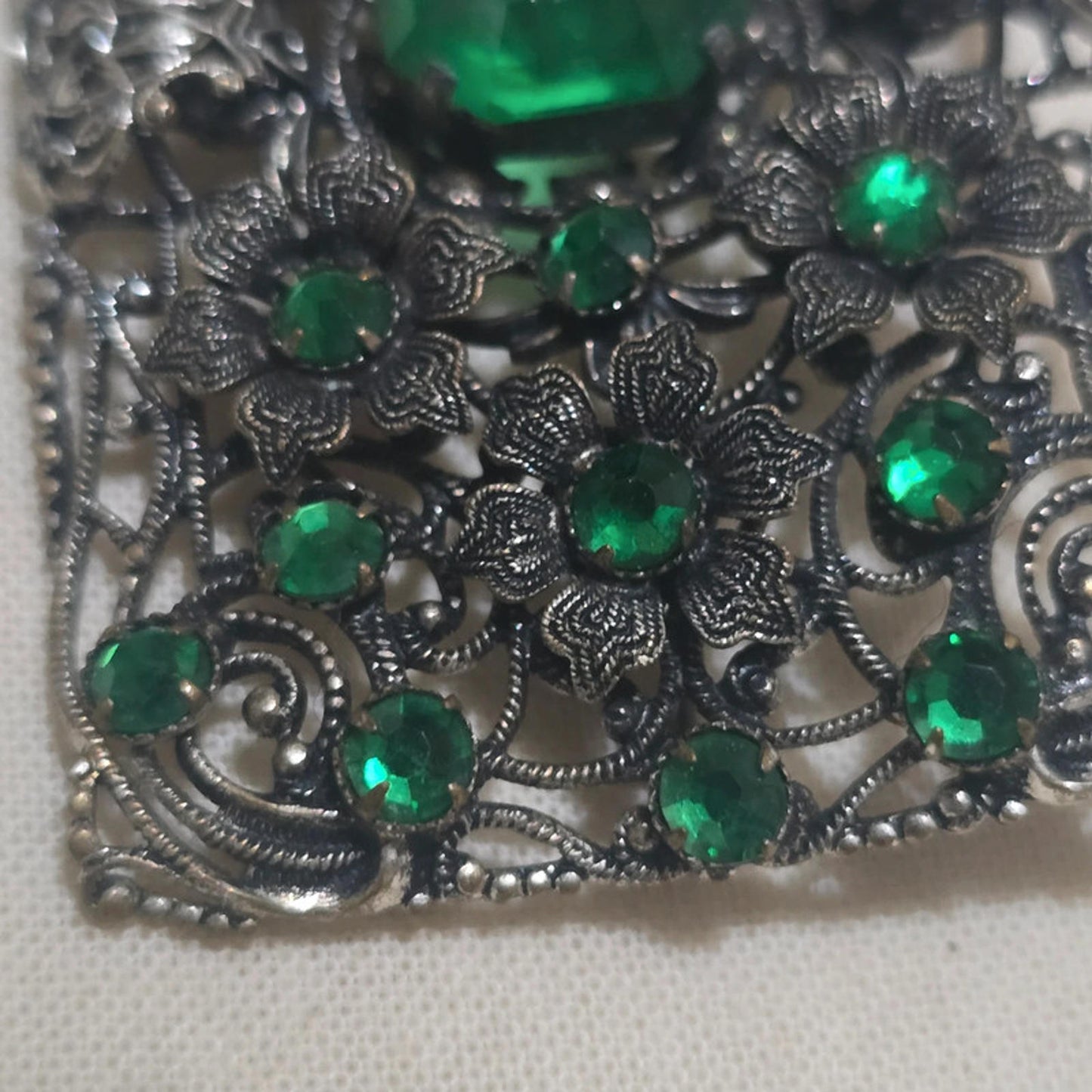 a stunning filigree and emerald green vintage brooch