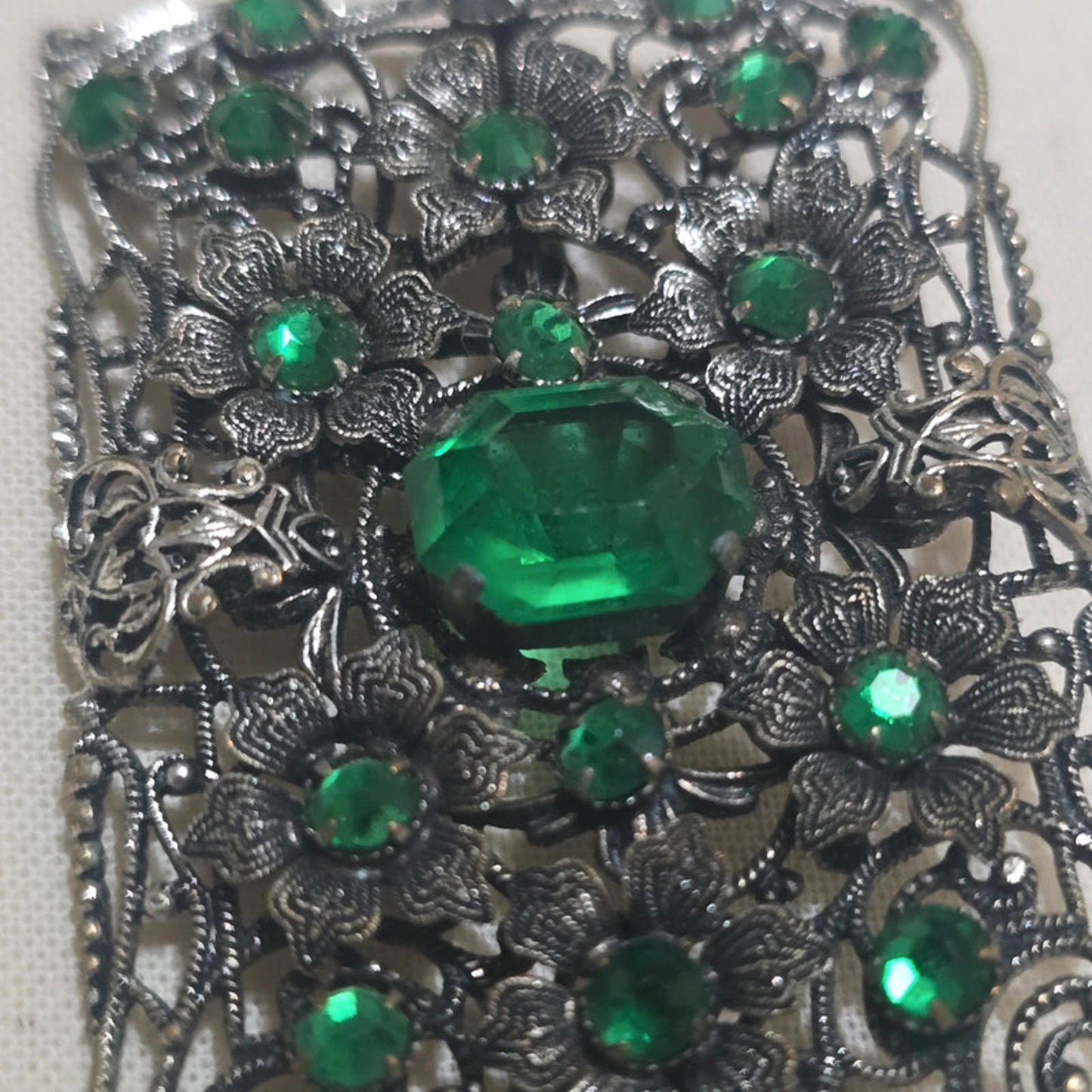 a stunning filigree and emerald green vintage brooch