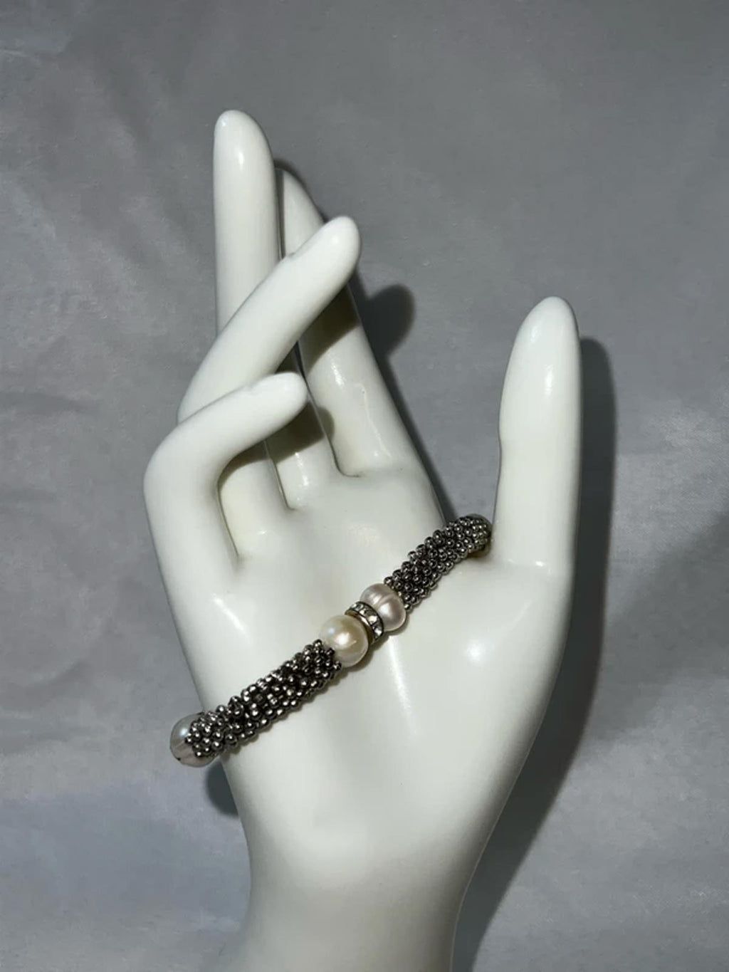 Silver colored bracelet with faux pearls