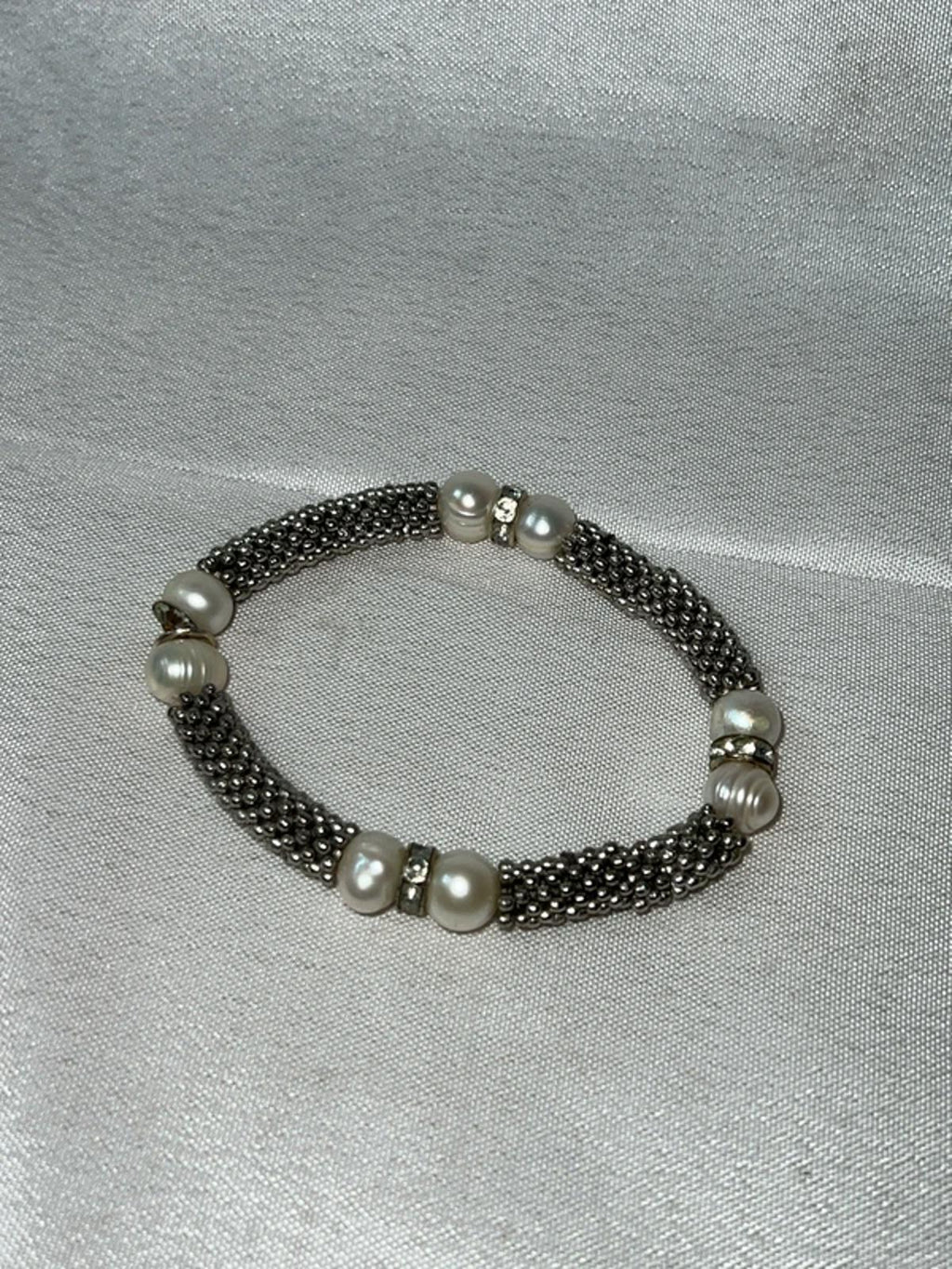 Silver colored bracelet with faux pearls