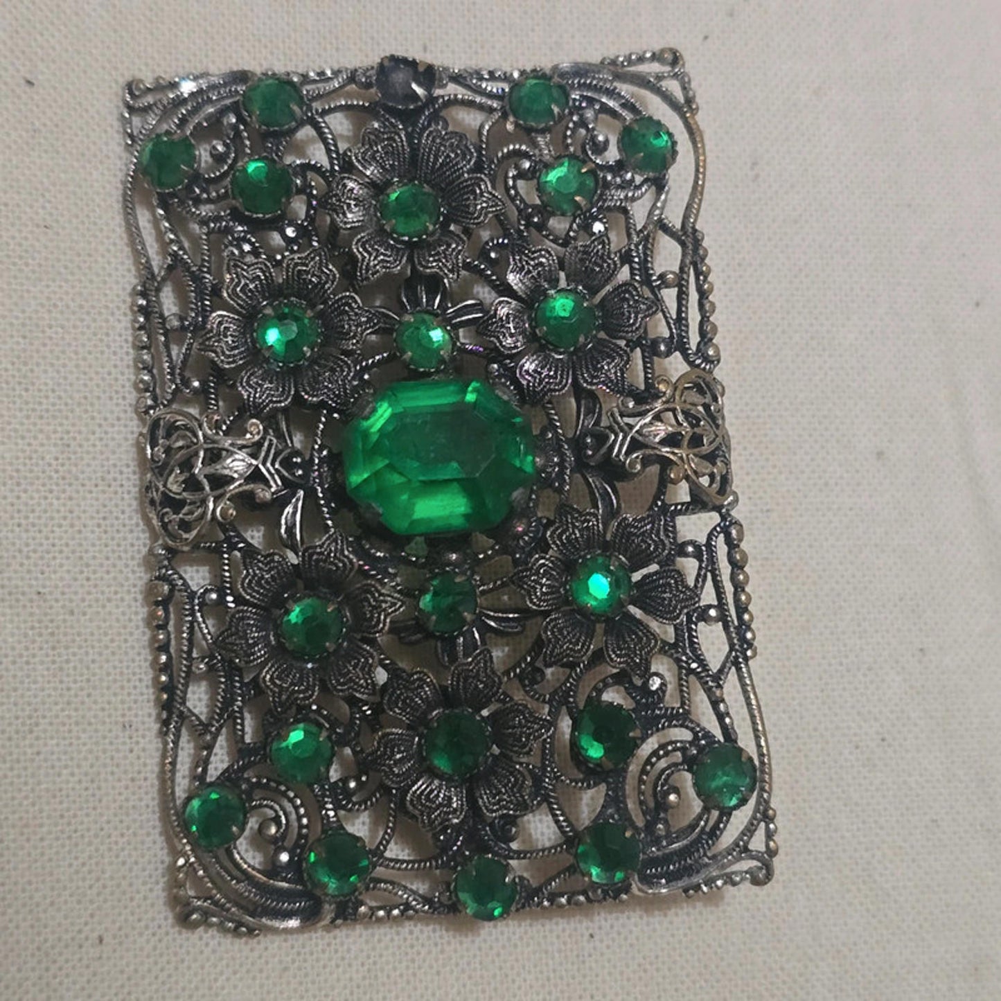 a stunning filigree and emerald green vintage brooch