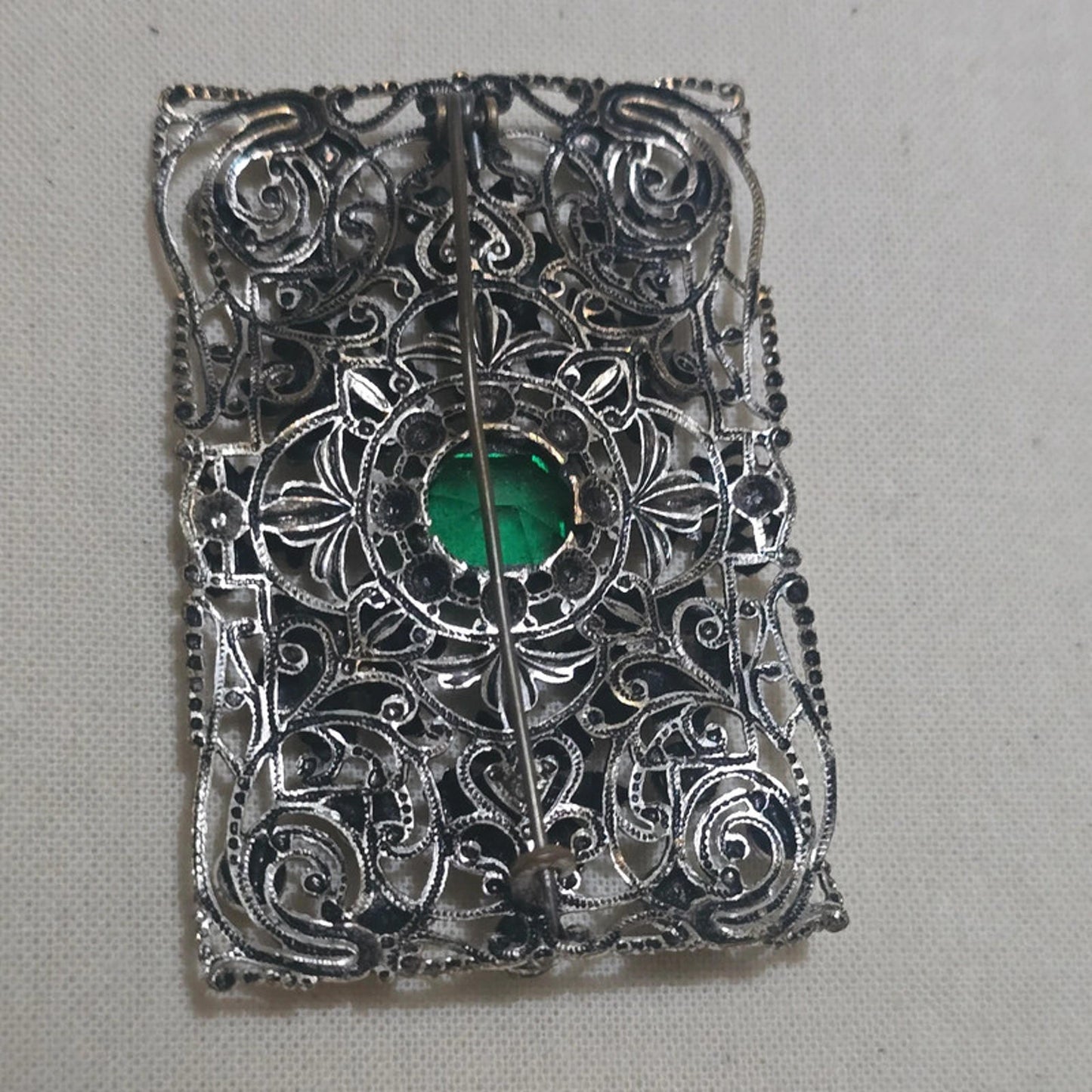 a stunning filigree and emerald green vintage brooch
