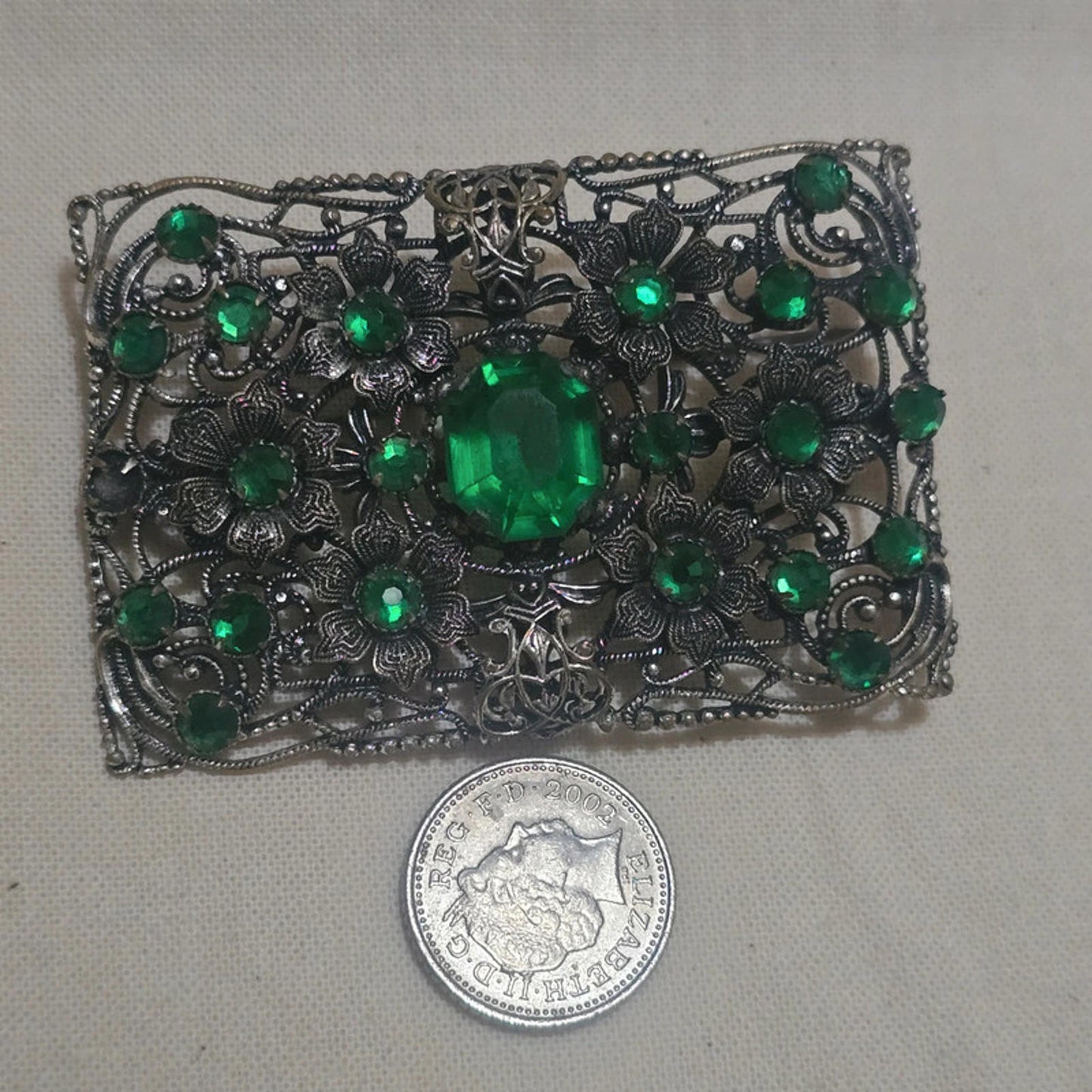 a stunning filigree and emerald green vintage brooch